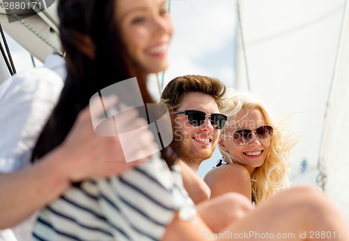 Image of smiling friends sitting on yacht deck