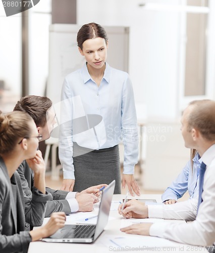 Image of strict female boss talking to business team