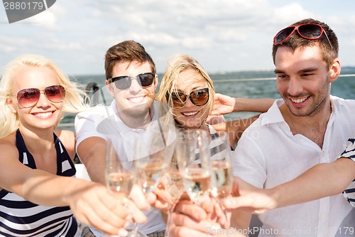 Image of smiling friends with glasses of champagne on yacht