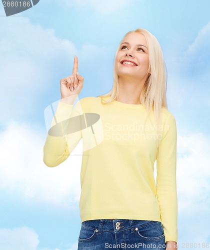 Image of smiling woman pointing her finger up