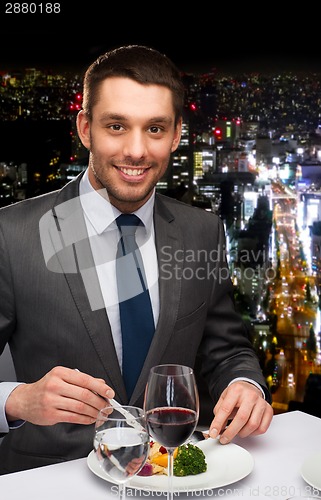 Image of smiling man eating main course