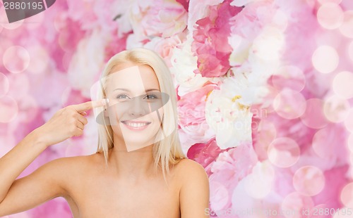Image of beautiful woman touching her eye area