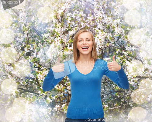 Image of smiling girl in casual clothes showing thumbs up