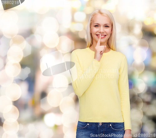 Image of young woman with finger on her lip