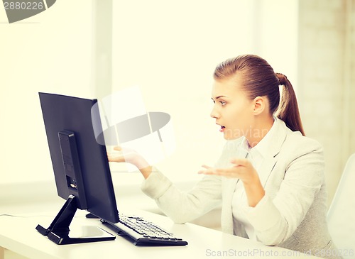 Image of stressed student with computer in office