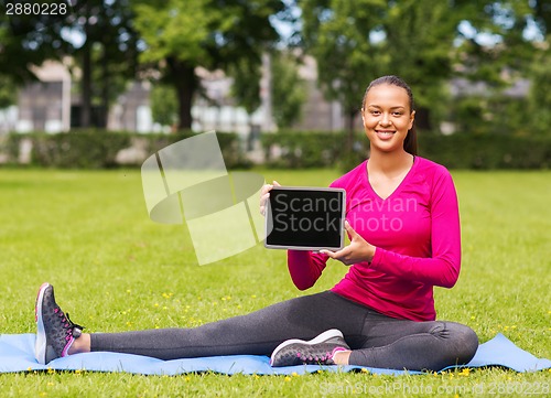 Image of smiling woman with tablet pc outdoors