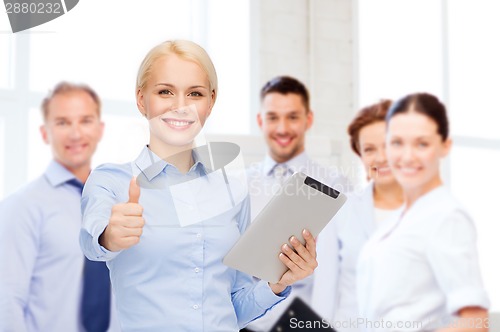 Image of smiling woman looking at tablet pc computer