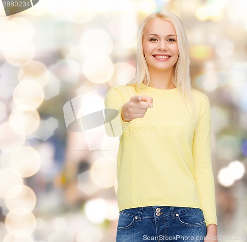 Image of smiling woman pointing finger at you