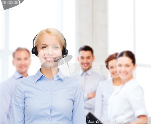 Image of friendly female helpline operator with headphones