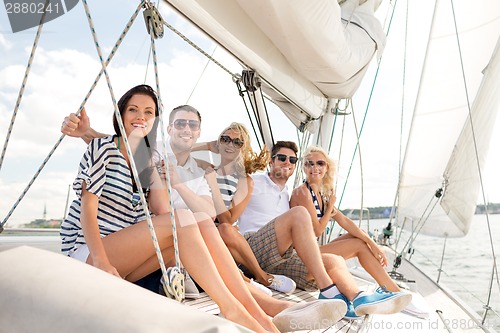 Image of smiling friends sitting on yacht deck