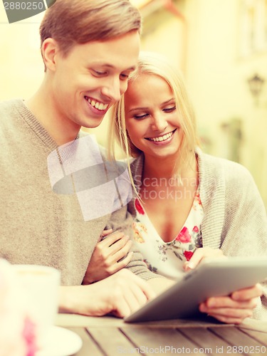 Image of smiling couple with tablet pc computer in cafe