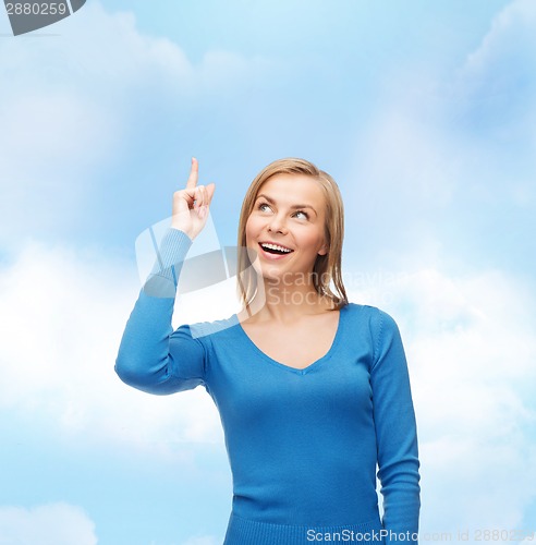 Image of smiling woman pointing her finger up