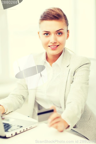 Image of businesswoman with laptop using credit card