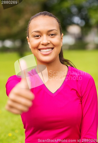 Image of smiling african american woman showing thumbs up