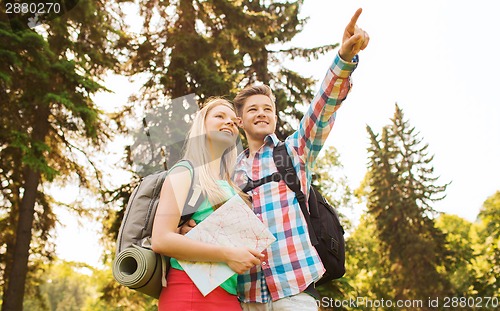 Image of smiling couple with map and backpack in nature