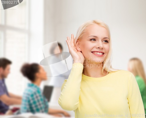 Image of smiling young woman listening to gossip