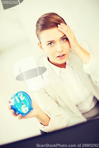 Image of stressed businesswoman holding clock