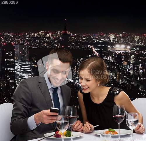 Image of smiling couple eating main course at restaurant