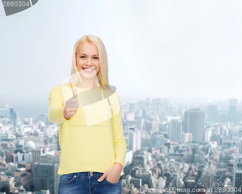 Image of smiling girl in casual clothes showing thumbs up