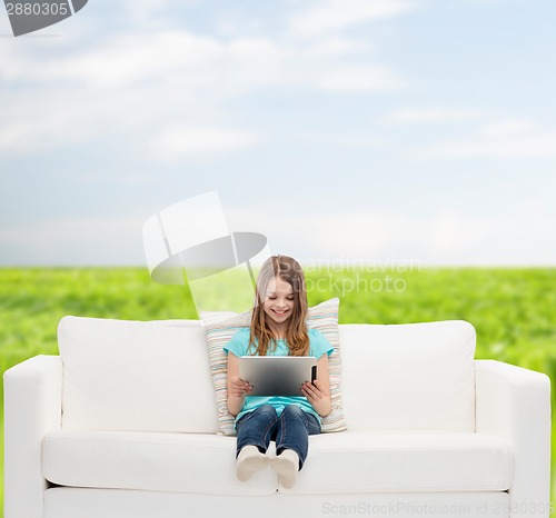 Image of little girl sitting on sofa with tablet pc