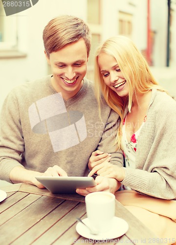 Image of couple looking at tablet pc in cafe