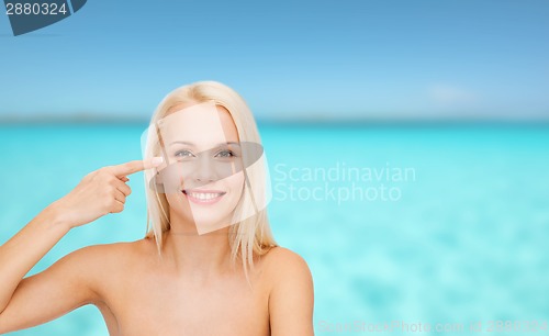 Image of beautiful woman touching her eye area