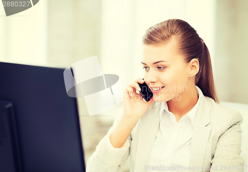 Image of businesswoman with smartphone in office