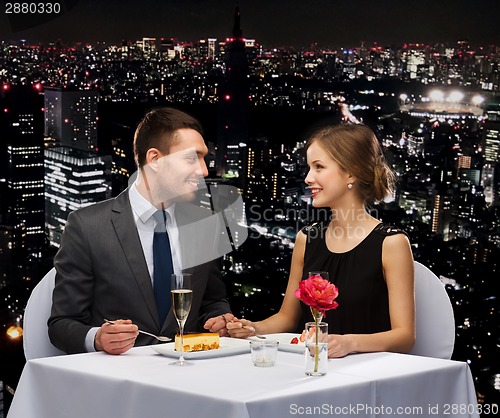 Image of smiling couple eating dessert at restaurant