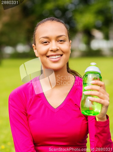 Image of smiling teenage girl showing bottle