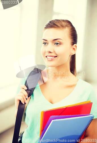 Image of student girl with school bag and color folders