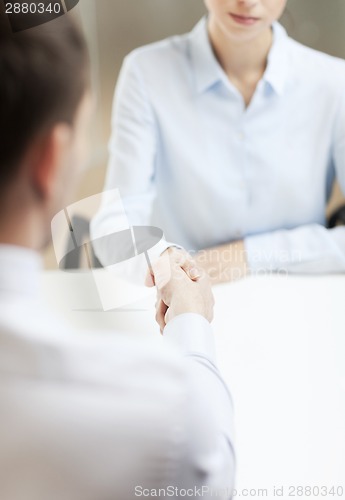 Image of businesswoman and businessman shaking hands