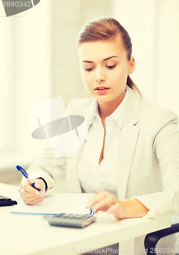 Image of businesswoman with notebook and calculator