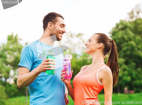 Image of smiling couple with bottles of water outdoors