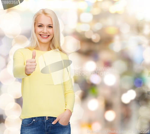 Image of smiling girl in casual clothes showing thumbs up