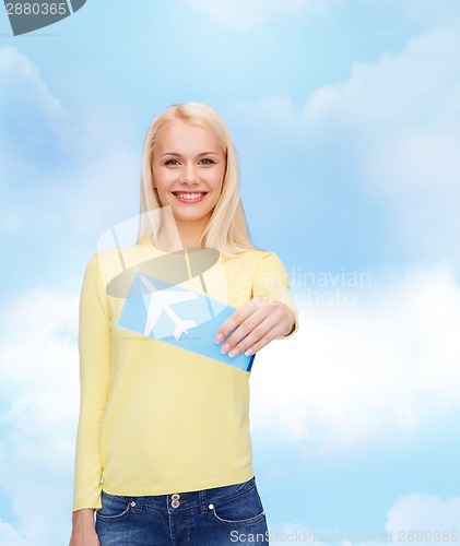 Image of smiling young woman with airplane ticket