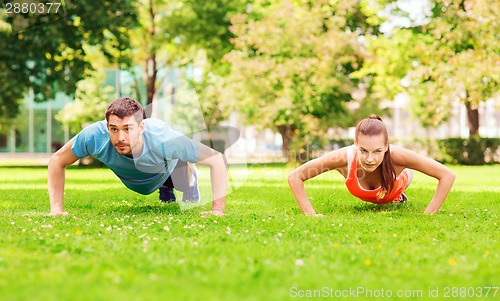 Image of couple doing push-ups outdoors
