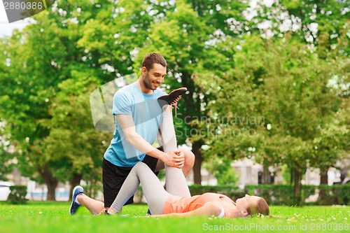 Image of smiling couple stretching outdoors