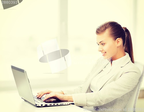 Image of businesswoman with laptop in office