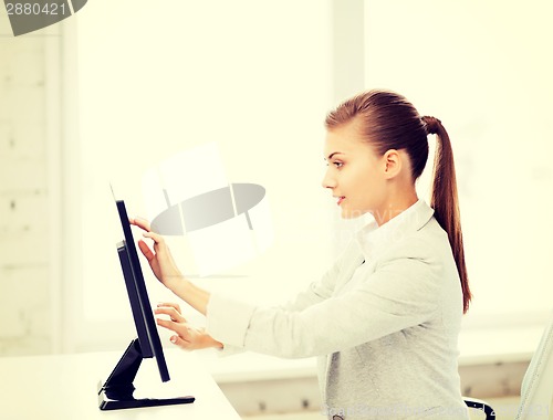 Image of smiling businesswoman with touchscreen in office