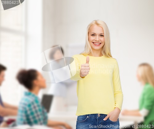 Image of smiling girl in casual clothes showing thumbs up