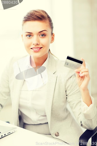 Image of businesswoman with laptop showing credit card