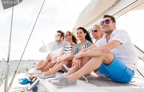 Image of smiling friends sitting on yacht deck