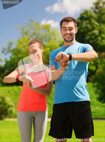 Image of smiling people with heart rate watches outdoors