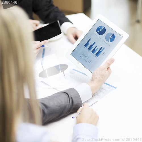 Image of business team with graph on tablet pc screen