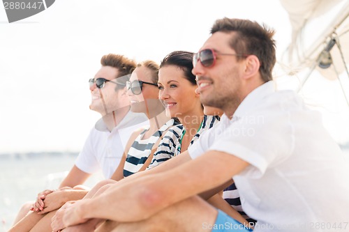 Image of smiling friends sitting on yacht deck