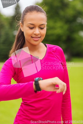 Image of smiling young woman with heart rate watch