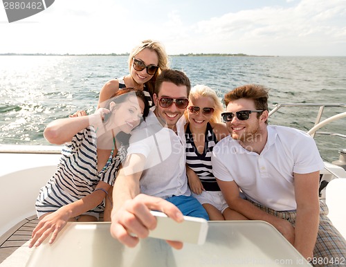 Image of smiling friends sitting on yacht deck