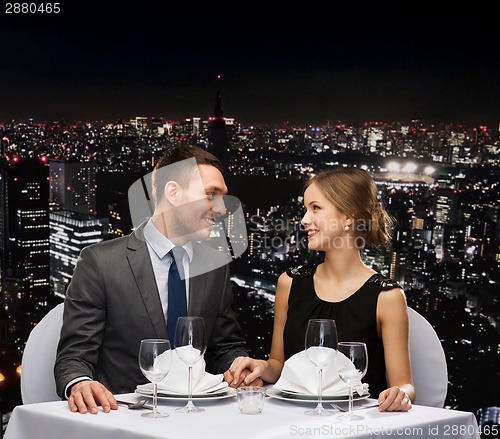 Image of smiling couple looking at each other at restaurant
