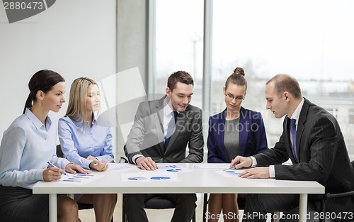 Image of business team with documents having discussion