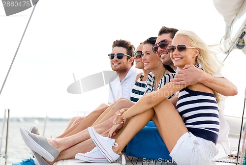 Image of smiling friends sitting on yacht deck